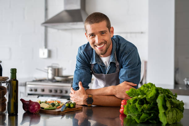 Young man leaning on kitchen counter