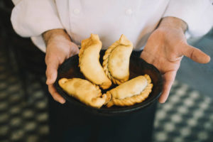 Close up of chef holding fresh empanadas