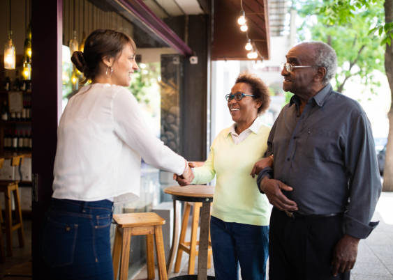 Woman shaking hands with elderly couple