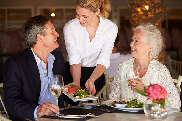 Waitress Serving Food To Senior Couple